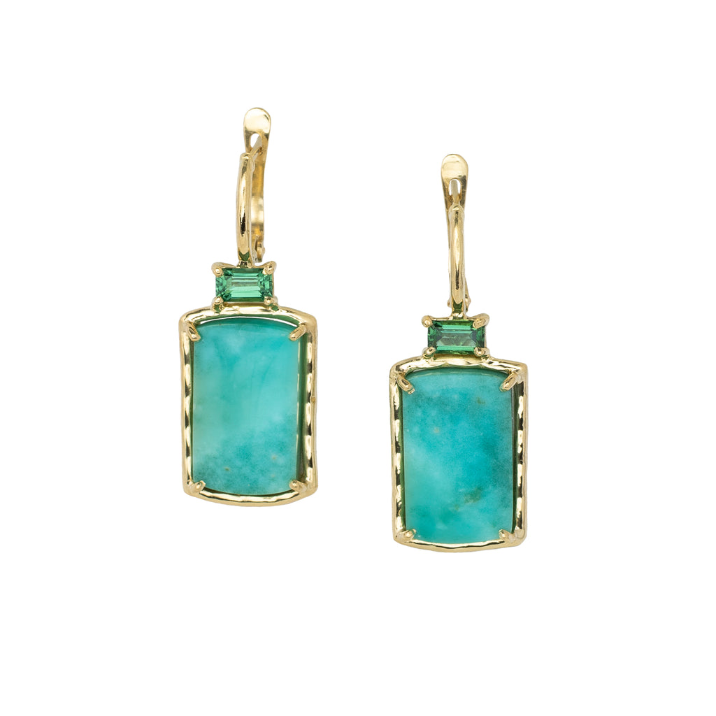 Pair of earrings with turquoise hued stones and gold frames on a white background